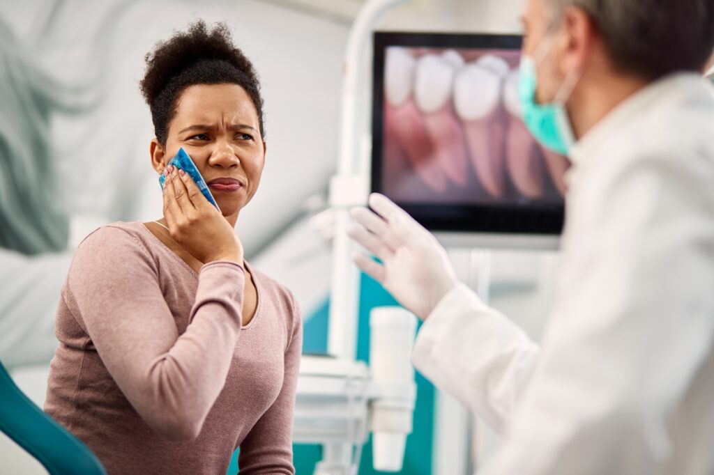 Patient holding their jaw while experiencing a severe toothache before visiting Crescent Dental in Orlando